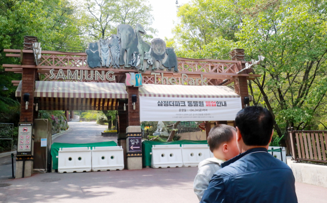 지난달 25일 개원 6년 만에 폐쇄된 '삼정 더파크'의 출입문이 가로막혀 있어요. 이를 바라보는 아이와 어른의 뒷모습이 씁쓸해 보입니다. 부산일보DB