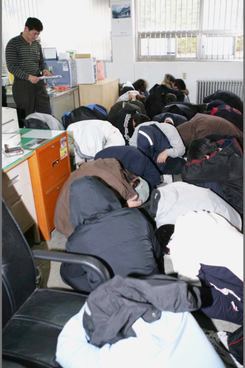 2004년 12월 7일 울산남부경찰서에서 집단 성폭행으로 경찰에 붙잡힌 경남 밀양 학교 폭력배 30여 명이 고개를 숙이고 있다. 연합뉴스