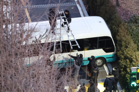 고위공직자범죄수사처(공수처)와 경찰이 윤석열 대통령에 대한 2차 체포영장 집행에 나선 15일 서울 용산구 한남동 대통령 관저 입구에서 경찰이 차벽을 넘기 위해 사다리를 설치하고 있다. 연합뉴스