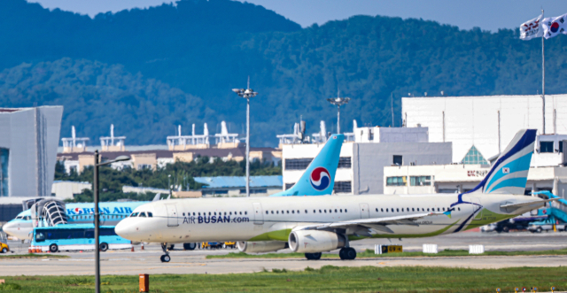 김해국제공항 활주로에서 에어부산 여객기가 대한항공 여객기 앞을 지나가는 모습. 부산일보DB