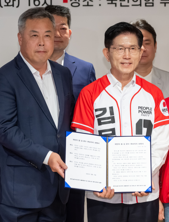 김문수 국민의힘 대선 후보가 13일 부산 수영구 국민의힘 부산시당에서 열린 한국노총 부산지역 단위노동조합 대표자 김문수 후보 지지선언 행사에서 박진수(왼쪽) 부산 선대위 공동선대위원장으로부터 지지 성명서를 받고 있다. 김종진 기자 kjj1761@