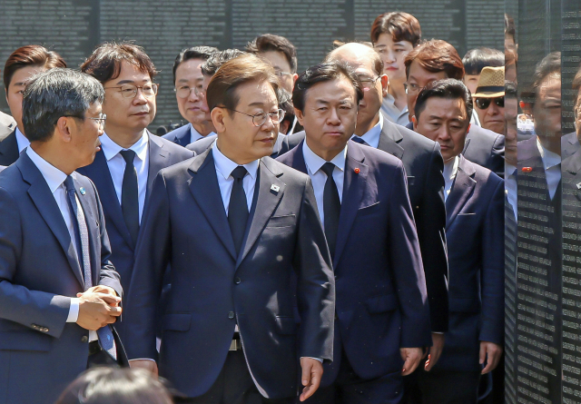 더불어민주당 이재명 대선후보가 14일 6.25 전쟁으로 희생된 유엔군 장병들이 영면해 있는 부산 남구 유엔기념공원 찾아 묘역을 둘러보며 이동하고 있다. 김종진 기자 kjj1761@
