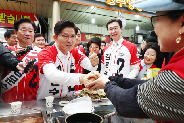 국민의힘 김문수 대선후보가 14일 경남 진주 진주중앙시장을 찾아 시민들과 악수하며 대선에서의 지지를 호소하고 있다. 연합뉴스