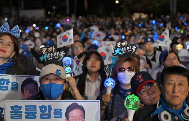 4일 서울 여의도 국회 인근에서 더불어민주당 주최로 열린 제21대 대통령 선거 국민개표방송 행사에 참석한 시민들이 당선이 확실시되는 이재명 대선 후보의 연설을 듣고 있다. 연합뉴스