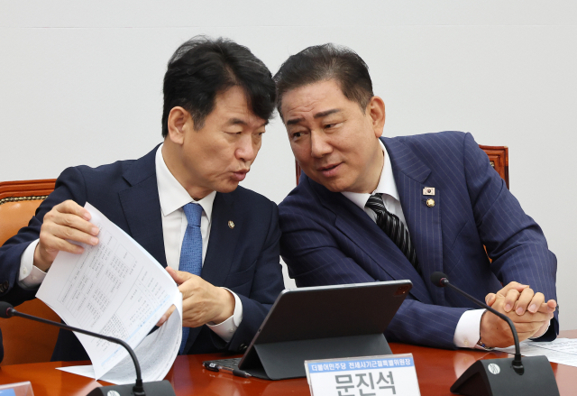 더불어민주당 김병기 당 대표 직무대행 겸 원내대표(오른쪽)가 3일 국회에서 열린 신탁사기 피해자 구제를 위한 사회적 협약식에 참석해 전세사기근절특별위원장을 맡고 있는 문진석 원내수석부대표와 대화하고 있다. 연합뉴스
