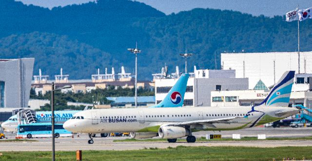 김해국제공항 활주로에 에어부산 여객기가 대한항공 여객기 앞을 지나가고 있다. 부산일보DB
