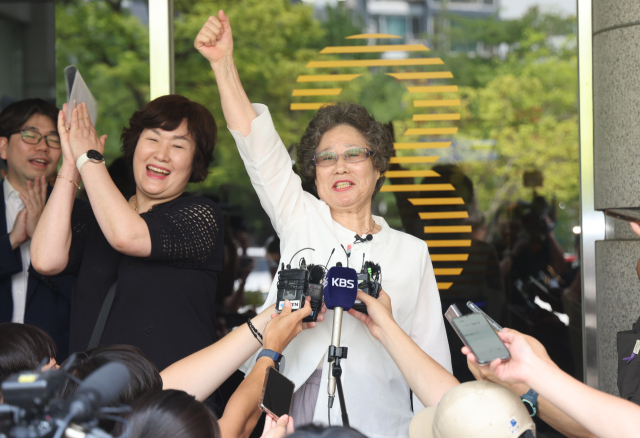 61년 전 자신을 성폭행하려던 남성의 혀를 깨물어 중상해 혐의로 유죄 판결을 받았던 최말자 씨가 23일 오전 부산지방법원에서 열린 재심 첫 공판을 마치고 법정을 나서며 손을 치켜들고 있다. 이재찬 기자 chan@