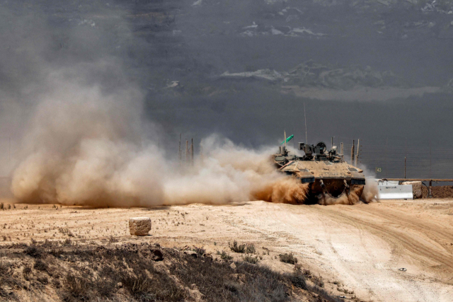 이스라엘군 보병 전투 차량이 5일(현지 시간) 가자지구 남쪽 국경을 따라 이동하면서 먼지 구름을 남기고 있다. AFP연합뉴스