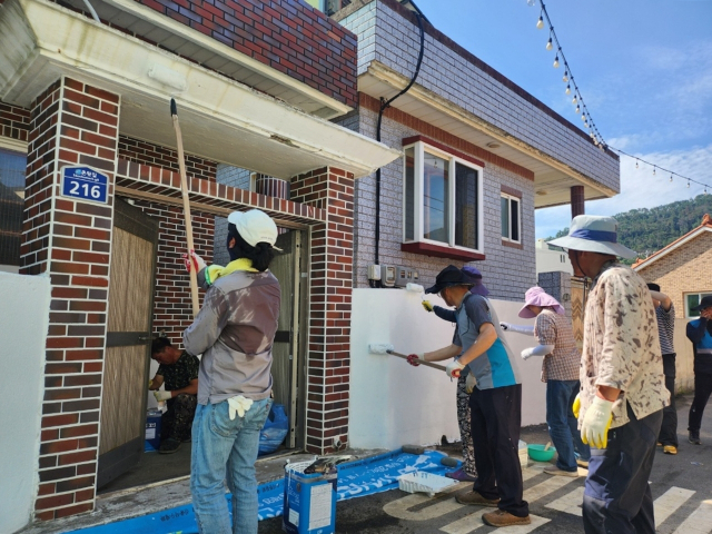 통영시 욕지도 주민들이 새로 전입하는 가족이 생활할 빈집을 손수 정비하고 있다. 부산일보DB