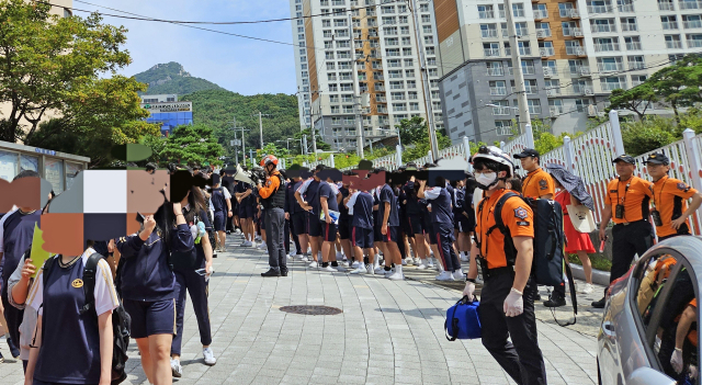 지난 8일 부산 북구의 한 중학교 학생들이 폭발 테러 예고 사실이 알려진 직후 학교 밖으로 대피하고 있다. 부산소방재난본부 제공