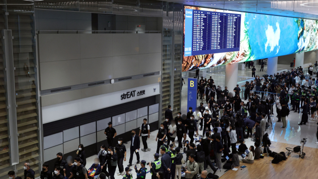 캄보디아 온라인 사기에 가담해 구금된 한국인들이 18일 오전 인천국제공항 제2터미널을 통해 송환되고 있다. 이날 송환에는 경찰 호송조 190여명이 투입됐다. 연합뉴스