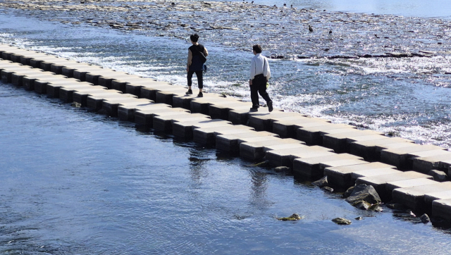 한 부부가 용두산 잔도로 이어지는 경남 밀양시 밀양강 콘크리트다리를 건너고 있다. 남태우 기자