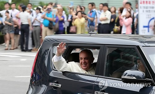 프란치스코 교황이 2014년 8월 14일 서울공항을 통해 입국해 서울 궁정동 교황청 대사관으로 이동하면서 시민들에게 손을 들어 인사하고 있다. 연합뉴스
