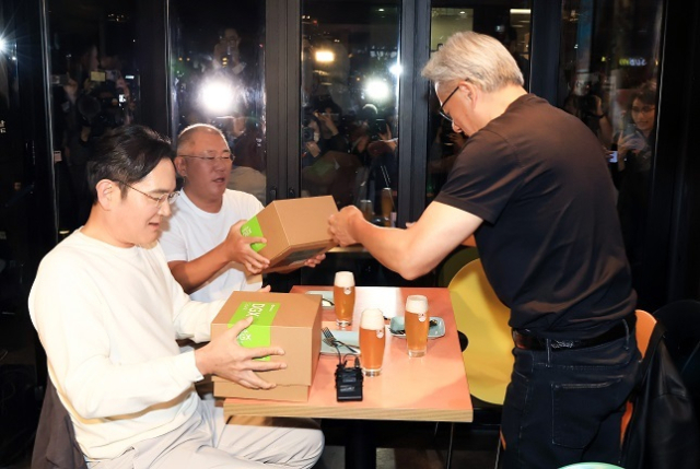 젠슨 황 엔비디아 최고경영자(CEO)가 30일 오후 서울 강남구 삼성역 인근 깐부치킨 매장에서 진행된 회동에서 이재용 삼성그룹 회장, 정의선 현대차그룹 회장에게 선물을 전달하고 있다. 연합뉴스
