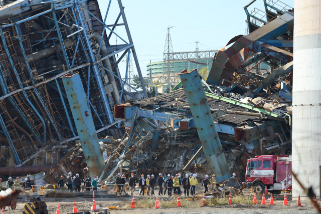 울산 동서발전 화력발전소 붕괴 사고 엿새째인 11일 오후 보일러 타워 4호기와 6호기가 발파 해체한 후 중앙사고수습본부 관계자들이 실종자 수색 재개를 위해 현장을 살피고 있다. 이날 중수본은 보일러타워 4호기와 6호기를 발파한 뒤 본격적으로 사고가 난 5호기 주변 실종자 수색에 나섰다. 연합뉴스