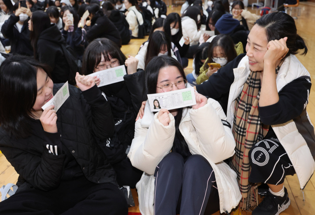 2026학년도 대학수학능력시험을 하루 앞둔 지난달 12일 부산 사상구 주례여고 대강당에서 고3 담임교사가 제자들에게 수험표를 나눠주며 격려하고 있다. 정종회 기자 jjh@