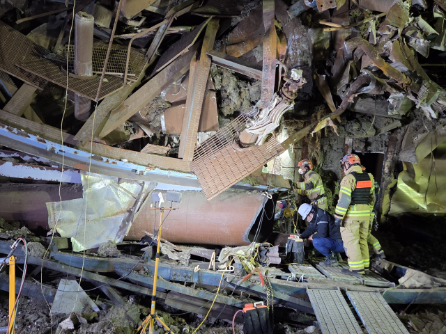 12일 저녁 울산화력발전소 붕괴 사고 현장, 울산소방본부 구조 대원들이 조명에 의지한 채 철골 잔해를 그라인더로 절단하며 매몰자 수색에 총력을 기울이고 있다. 울산소방본부 제공