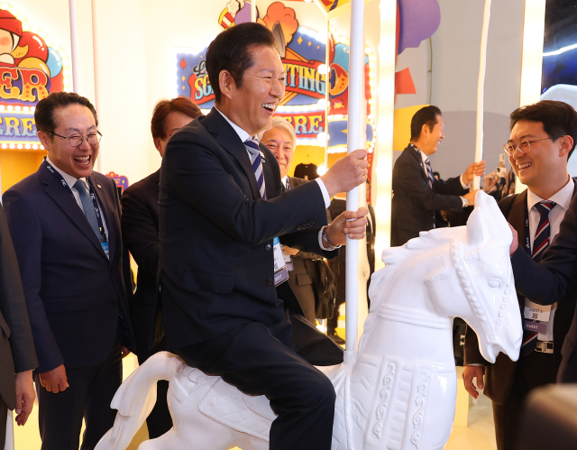 더불어민주당 정청래 대표가 14일 오후 부산 해운대구 벡스코에서 열리고 있는 국제게임전시회 지스타2025를 찾아 포토존으로 꾸며진 회전목마에 올라타고 있다. 연합뉴스