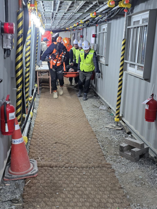 19일 울산 울주군 샤힌프로젝트 공사 현장 비계가 무너져 내리면서 현장 관계자와 구조대원들이 들것을 이용해 부상당한 작업자를 이송하고 있다. 민주노총 전국플랜트건설노조 울산지부 제공