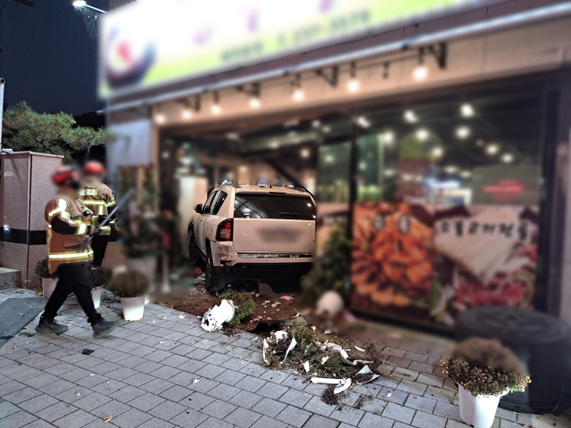 19일 오후 울산 울주군에서 SUV 차량이 영업 중인 식당으로 돌진해 입구 유리창과 벽면을 뚫고 들어갔다. 현장에는 사고 충격으로 부서진 잔해물과 화분에서 쏟아진 흙더미가 차량 주변에 널려 있다. 연합뉴스