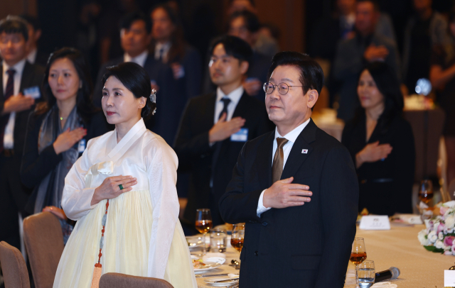 이집트를 공식 방문 중인 이재명 대통령과 김혜경 여사가 20일(현지시간) 카이로의 한 호텔에서 열린 동포·지상사 간담회에서 국기에 경례하고 있다. 연합뉴스