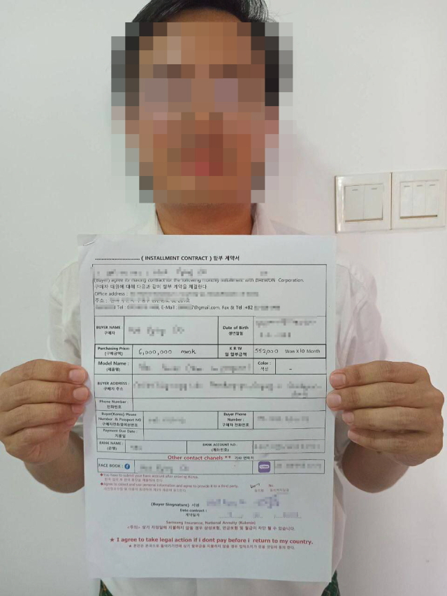 A씨 일당이 불법 대출을 한 외국인 근로자가 대부 관련 계약서를 들고 있다. 부산경찰청 제공