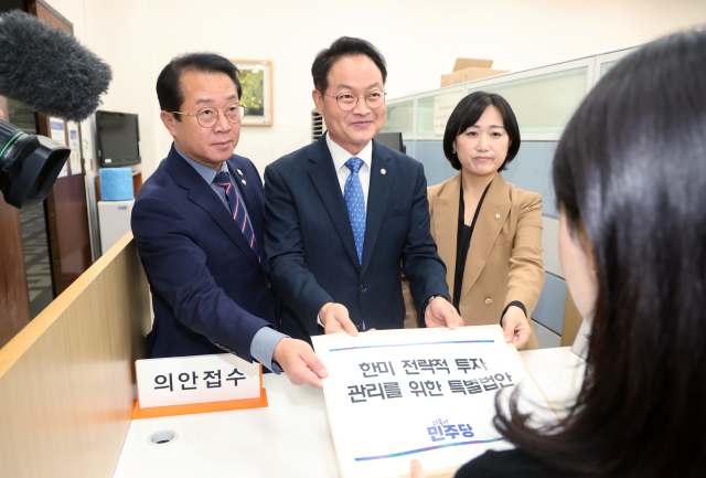 더불어민주당 허영 원내정책수석부대표(가운데)와 문금주, 백승아 원내부대표가 26일 서울 여의도 국회 의안과에 한미 전략적 투자관리를 위한 특별법안을 제출하고 있다. 연합뉴스