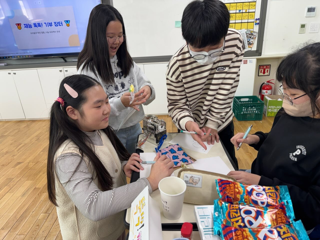 회야초등 4학 3반 학생들이 ‘재능 톡톡, 나눔장터’를 운영한 뒤 얻은 수익금을 어려운 이웃들에게 써달라며 덕계동 행정복지센터에 기탁했다. 양산시 제공