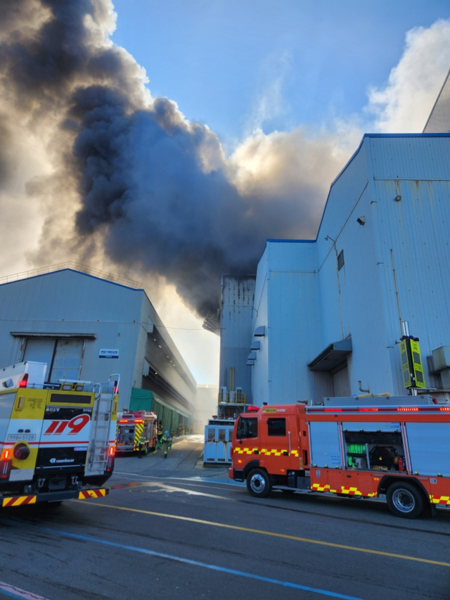 28일 오전 울산시 동구 HD현대일렉트릭 공장에서 굉음과 함께 화재가 발생해 검은 연기가 치솟고 있다. 신고를 받고 출동한 소방 당국이 펌프차 등 장비를 투입해 긴급 진화 작업을 벌이고 있다. 울산소방본부 제공