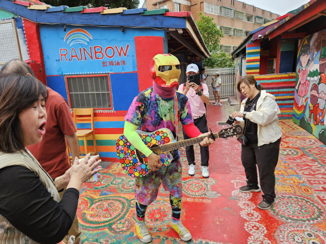 타이중 무지개마을 명물인 ‘아이언맨’이 기타를 치면서 엽서를 써주는 퍼포먼스를 선보여 큰 인기를 끌고 있다.