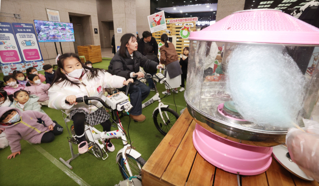 8일 부산시청 로비와 들락날락에서 진행된 ‘우리동네 15분도시 해피빌리지’ 행사에서 어린이들이 ‘친환경 솜사탕 자전거’ 체험을 하고 있다. 정종회 기자 jjh@