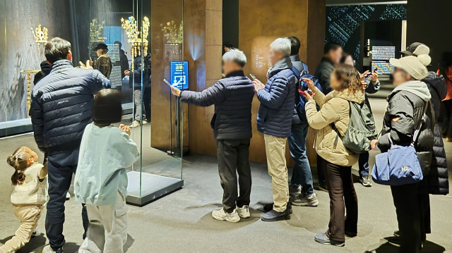 경북 경주시 국립경주박물관 ‘신라 금관’ 특별전을 찾은 관람객들이 황남대총 북분 금관 앞에서 사진을 찍고 있다. 남태우 기자