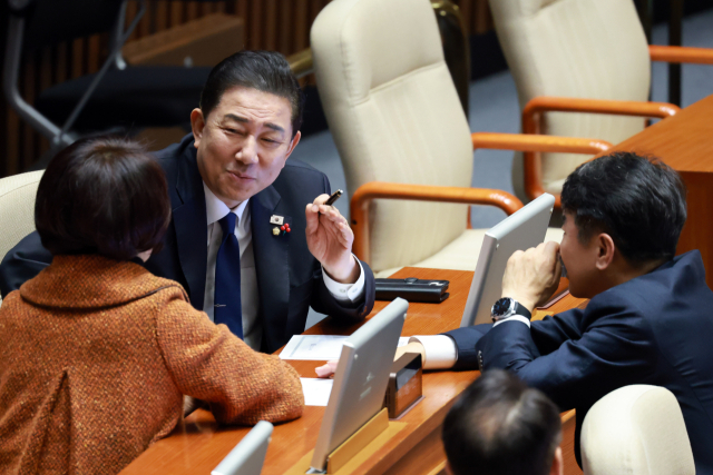 더불어민주당 김병기 원내대표가 13일 국회에서 열린 12월 임시국회 본회의에 참석해 한정애 정책위의장, 문진석 원내운영수석과 대화하고 있다. 연합뉴스