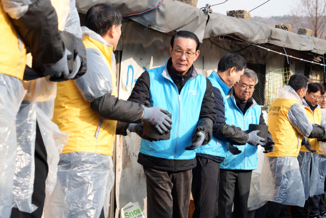 수협중앙회과 Sh수협은행은 연말연시를 맞아 지난 17일 서울 개포동 구룡마을 일대에서 ‘사랑의 연탄’ 봉사활동을 실시했다. 노동진 수협중앙회장(가운데), 신학기 Sh수협은행장, 김기성 수협중앙회 대표 등이 함께 연탄릴레이를 하는 모습. 수협 제공
