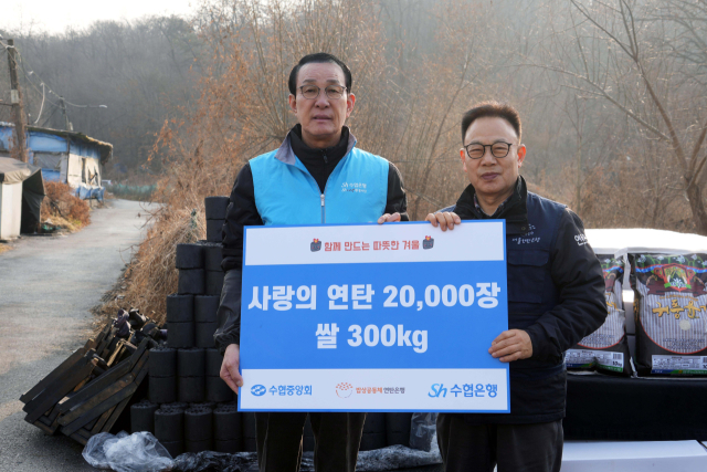 수협중앙회와 Sh수협은행은 연말연시를 맞아 지난 17일 서울 개포동 구룡마을 일대에서 ‘사랑의 연탄’ 봉사활동을 실시했다. 노동진 수협중앙회장(왼쪽)이 허기복 연탄은행 대표에게 연탄 2만 장과 쌀 300kg을 전달하며 기념사진을 찍는 모습. 수협 제공