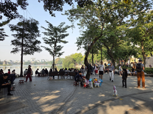 주말을 맞아 차 없는 거리로 변신한 하노이 호안끼엠 호수 주변 보행로에서 시민과 관광객들이 자유롭게 산책하며 여유를 즐기고 있다. 호수변을 따라 배치된 벤치와 탁 트인 보행 공간이 ‘보행자 중심’으로 재설계된 도시의 모습을 보여주고 있다.