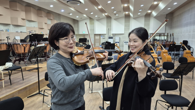 부산시립교향악단 바이올리니스트 배영주(왼쪽) 단원과 딸 권순지 단원이 13일 부산문화회관 내 부산시향 연습실에서 연주하는 포즈를 취하고 있다. 박석호 기자