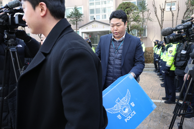 경찰이 14일 공천헌금 수수 등 각종 비위 의혹을 받는 더불어민주당 김병기 의원의 자택인 서울 동작구의 한 아파트에서 압수수색을 마친 뒤 압수품 상자를 들고 나서고 있다. 연합뉴스