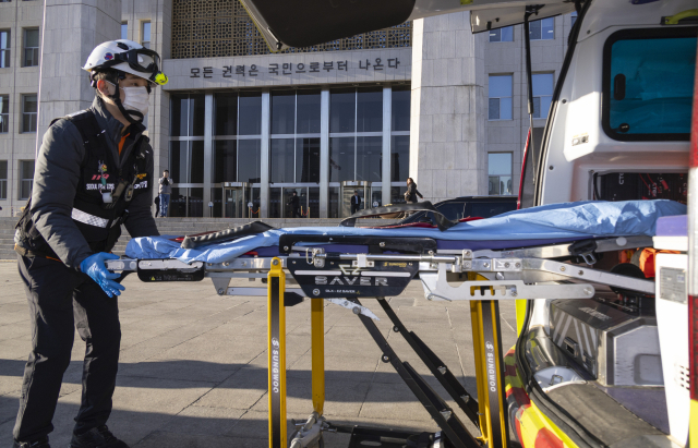 '쌍특검(통일교·공천헌금 의혹)' 도입을 요구하며 7일째 단식 중인 국민의힘 장동혁 대표의 건강 악화를 우려 당 중진 지도부들이 21일 오후 장 대표를 병원으로 옮기기 위해 119 구급대에 신고했다. 이에 119 구급대가 국회 본청에 출동해 장 대표를 옮기려 했지만 장 대표는 완강하게 병원행을 거부해 119 구급대는 다시 철수했다. 사진은 구급차에 장비를 다시 싣는 119 구조대원들. 연합뉴스