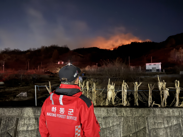 21일 전남 광양시 옥곡면 산불로 국가 소방동원령이 발령된 가운데 경남 하동군 산불진화대 대원이 양 지자체 경계지점에서 산불 확산 여부를 지켜보고 있다. 하동군 제공
