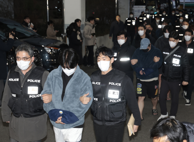 24일 부산경찰청 캄보디아 범죄조직 수사 태스크포스(TF)는 캄보디아에서 스캠(사기), 인질강도 등에 가담한 혐의로 23일 국내로 압송된 한국인 73명 중 49명에 대한 구속영장을 신청할 예정이라고 밝혔다. 사진은 강제 송환된 한국인 조직원 일부가 23일 부산 동래구 동래경찰서로 압송되는 모습. 정대현 기자 jhyun@