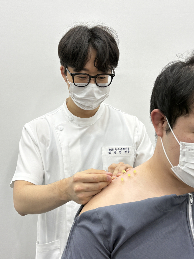 발목을 반복적으로 접지르거나, 허리를 자주 삐끗하는 등 근골격계의 안정성이 떨어지는 환자에게 한방 매선요법이 효과적이다. 사진은 365늘푸른한의원 임승찬 원장이 어깨 통증 환자에게 매선 치료를 하고 있는 모습. 365늘푸른한의원 제공
