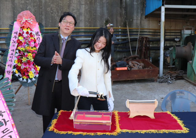 하피스트 박소윤 씨가 ‘대모’로 나서 손도끼로 선박에 연결된 진수줄을 잘랐다. 아시아조선 제공