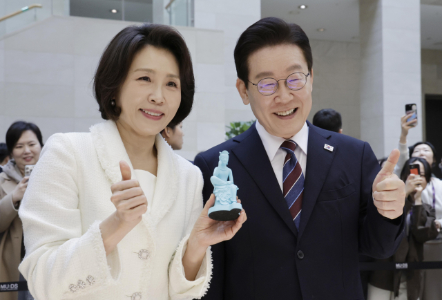 이재명 대통령과 김혜경 여사가 26일 서울 용산구 국립중앙박물관에서 열린 특별전 '우리들의 이순신'을 관람한 뒤 상품관에서 기념품과 함께 기념촬영을 하고 있다. 연합뉴스