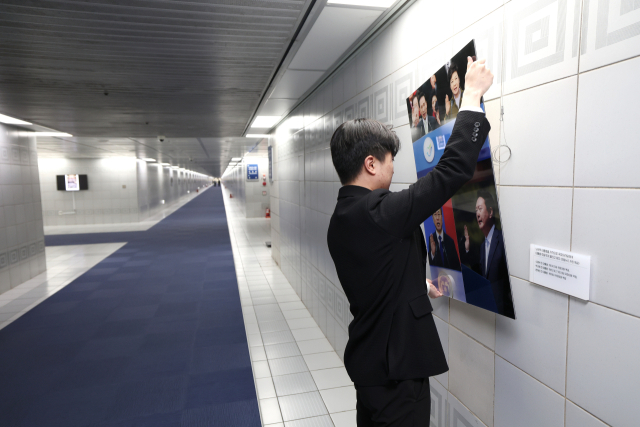 3일 국회 본관 지하통로에 전시된 사진 중 윤석열 전 대통령이 포함된 사진이 철거되고 있다. 국회의장실 제공