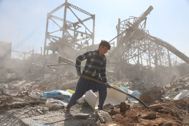4일(현지 시간) 이란 테헤란에서 한 소년이 파손된 건물의 잔해를 치우고 있다. 신화연합뉴스