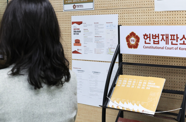 ‘최종심’인 대법원의 판결을 헌법재판소에서 다툴 수 있는 내용을 포함한 ‘사법개혁 3법’이 공표된 첫날인 지난 12일 서울 헌법재판소 민원실에서 관계자들이 안내문 비치 등을 점검하고 있다. 연합뉴스