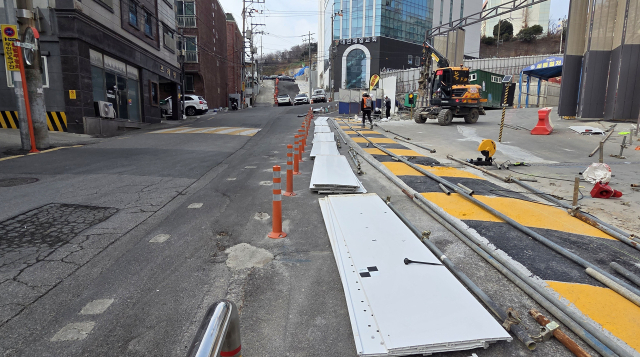 지난달 2일 부산 남구 대연중학교 후문 통학로 모습. 사전 허가를 받지 않은 게이트로 공사 차량이 다니며 공사 자재가 보행로에 방치된 상태다. 부산일보DB