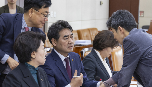 24일 국회에서 열린 국회 행정안전위원회 법안심사제1소위원회에서 위원장인 더불어민주당 윤건영 의원(오른쪽)과 국민의힘 행안위 간사인 서범수(왼쪽) 의원과 이성권 의원(가운데)이 부산 글로벌허브도시특별법 처리와 관련해 대화하고 있다. 연합뉴스