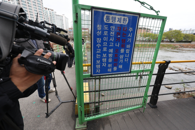 31일 대구 북구 칠성동 잠수교 아래 신천에서 여성의 시신이 담긴 캐리어가 발견된 가운데 캐리어가 발견된 지점에서 취재진이 취재하고 있다. 연합뉴스